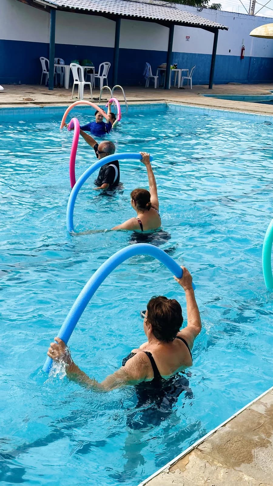 Participantes realizando uma atividade com arcos na piscina da AABB Pombal